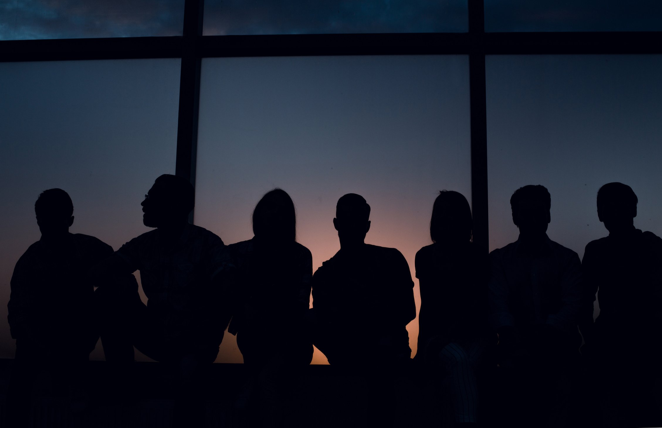 group of creative youth looks through the office windo